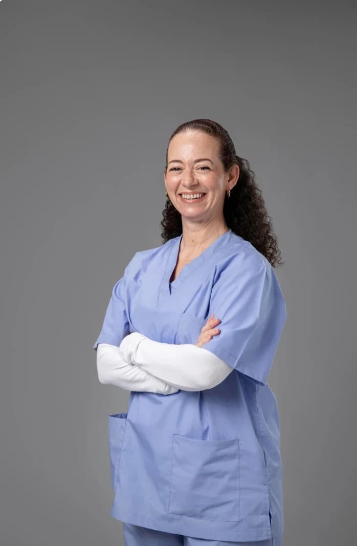 Asistente de endoscopía sonriendo, con ambo celeste